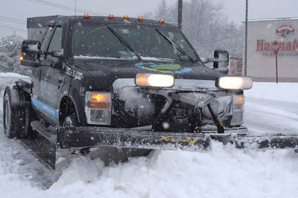 North Point truck plowing snow at a commercial property during a storm